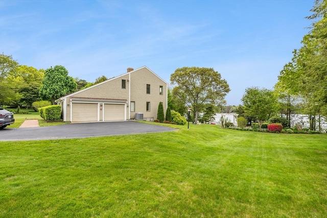 376 Flint St, Barnstable, MA 02648 - view of property exterior featuring asphalt driveway, a chimney, central AC, a yard, and a garage