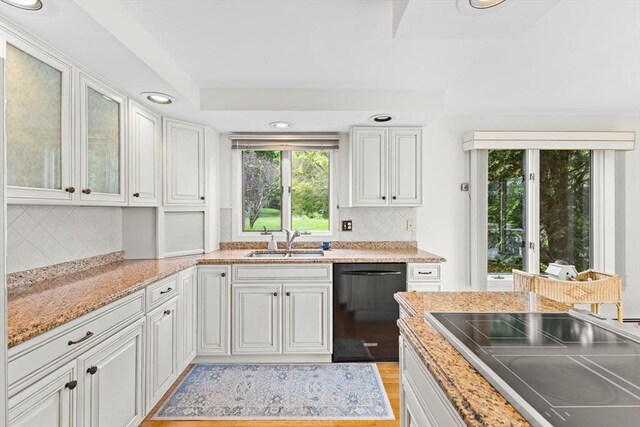 376 Flint St, Barnstable, MA 02648 - kitchen with black dishwasher, a sink, white cabinetry, backsplash, and recessed lighting