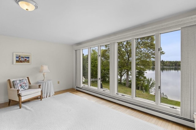 376 Flint St, Barnstable, MA 02648 - living area featuring a baseboard heating unit, a water view, baseboards, and wood finished floors