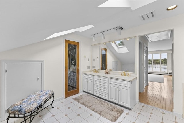 376 Flint St, Barnstable, MA 02648 - bathroom with a skylight, track lighting, a water view, double vanity, and lofted ceiling