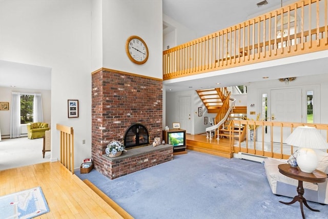 376 Flint St, Barnstable, MA 02648 - living room with a high ceiling, carpet, stairs, a brick fireplace, and baseboards
