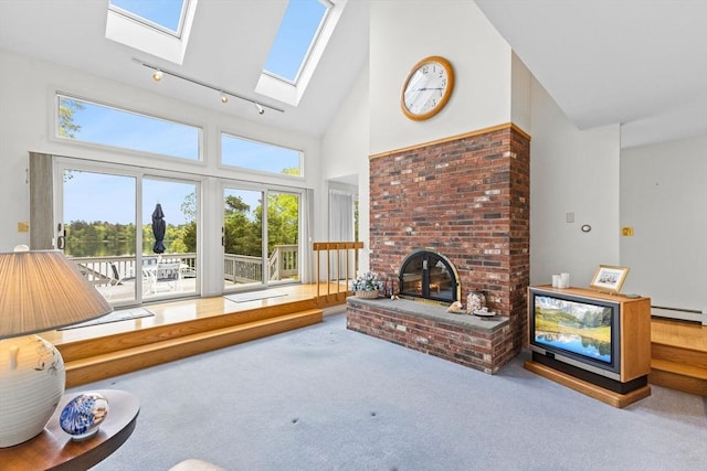 376 Flint St, Barnstable, MA 02648 - carpeted living area with high vaulted ceiling, baseboard heating, a skylight, a fireplace, and rail lighting
