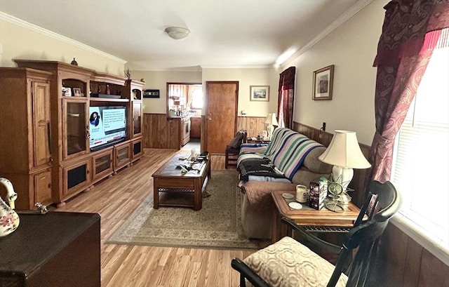 living area with a wainscoted wall, light wood finished floors, wood walls, and ornamental molding