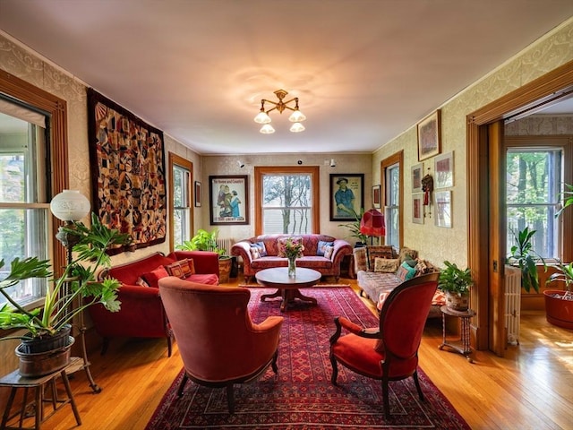 living area featuring wallpapered walls, light wood-style floors, and plenty of natural light