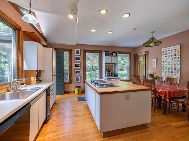 kitchen with dishwasher, stainless steel electric cooktop, a sink, white cabinetry, and recessed lighting