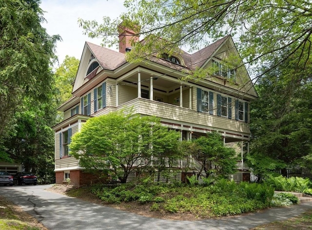 view of front of property featuring a balcony and a chimney