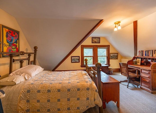 carpeted bedroom featuring vaulted ceiling and a desk