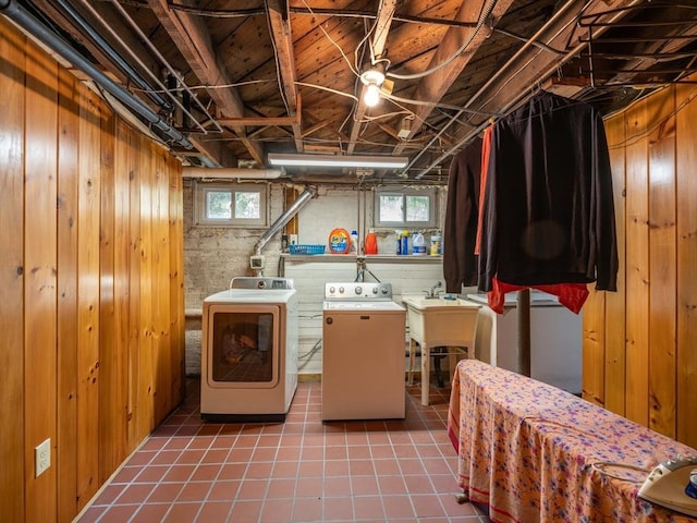 below grade area featuring washer and clothes dryer, tile patterned flooring, and wooden walls