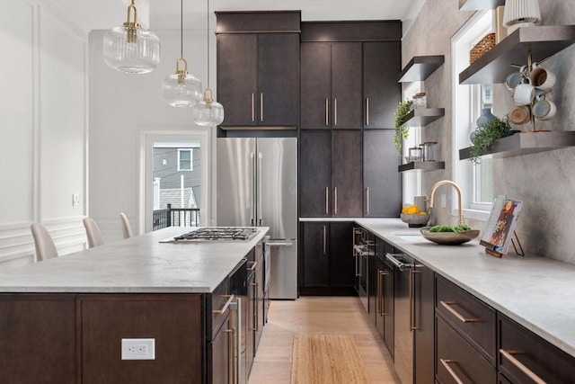 9 Russell Unit 2, Boston, MA 02129 - kitchen featuring open shelves, appliances with stainless steel finishes, light wood-type flooring, dark brown cabinetry, and a center island