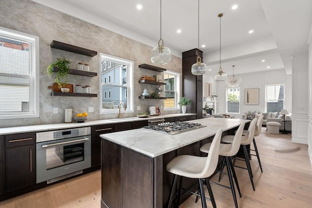 9 Russell Unit 2, Boston, MA 02129 - kitchen featuring appliances with stainless steel finishes, a sink, open shelves, a kitchen island, and a kitchen bar