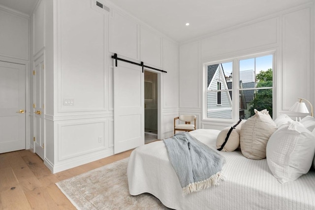 9 Russell Unit 2, Boston, MA 02129 - bedroom featuring a decorative wall, a barn door, light wood finished floors, recessed lighting, and ornamental molding
