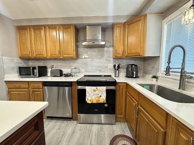 11 Marie Ave, Brockton, MA 02302 - kitchen with stainless steel appliances, wall chimney range hood, a sink, brown cabinetry, and tasteful backsplash