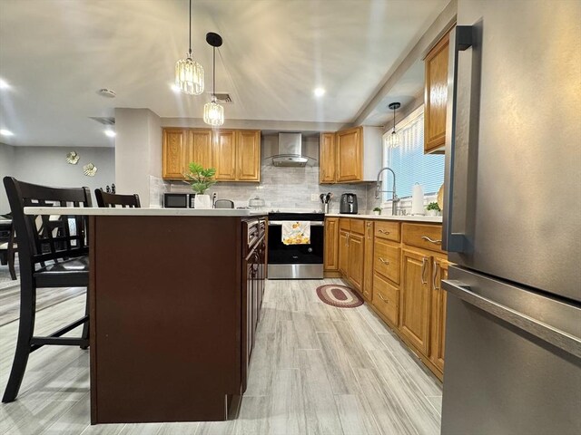 11 Marie Ave, Brockton, MA 02302 - kitchen with appliances with stainless steel finishes, tasteful backsplash, wall chimney range hood, hanging light fixtures, and light countertops