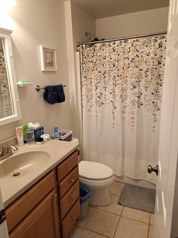 bathroom featuring vanity, tile patterned flooring, a shower with curtain, and toilet