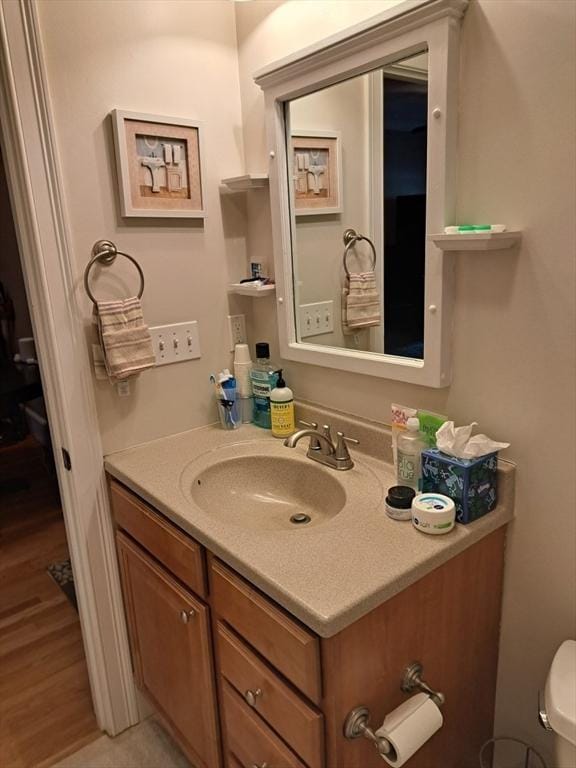 bathroom with vanity, wood finished floors, and toilet