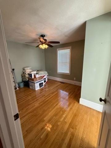 unfurnished bedroom featuring a ceiling fan, baseboards, and light wood finished floors