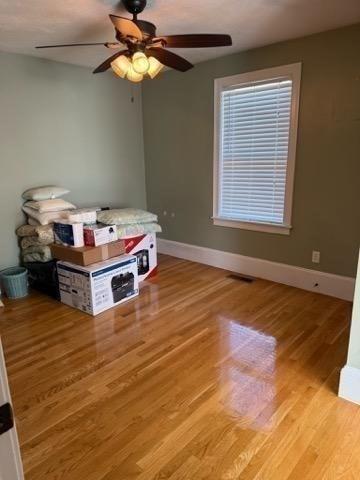 bedroom with a ceiling fan, baseboards, and light wood finished floors