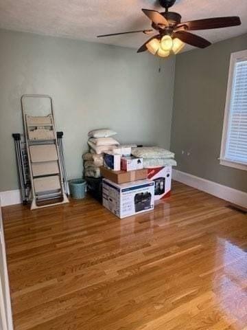 bedroom featuring baseboards, ceiling fan, and wood finished floors