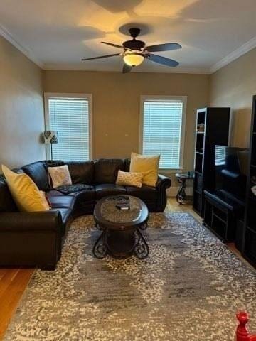 living area featuring plenty of natural light, a ceiling fan, crown molding, and wood finished floors