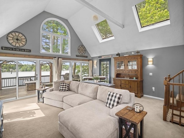 34 Lake Shore Dr S, Westford, MA 01886 - living room featuring high vaulted ceiling, a skylight, light colored carpet, stairway, and a water view