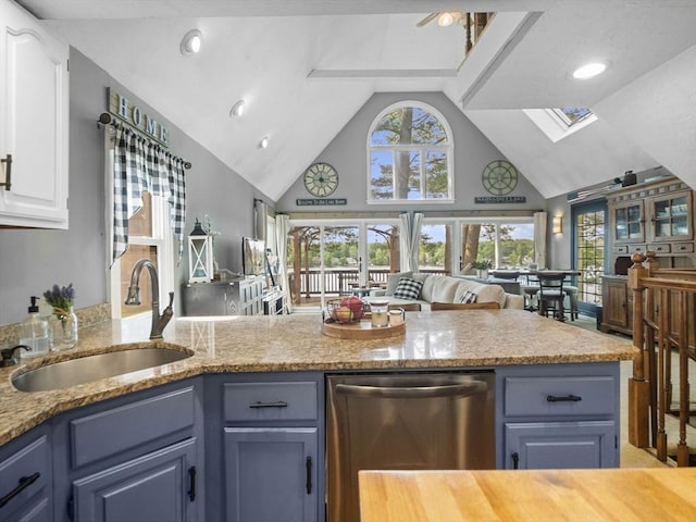 34 Lake Shore Dr S, Westford, MA 01886 - kitchen featuring stainless steel dishwasher, high vaulted ceiling, a sink, a skylight, and blue cabinetry