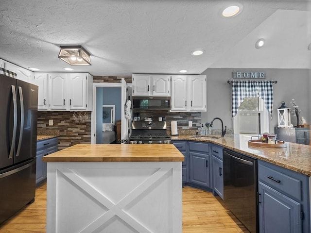 34 Lake Shore Dr S, Westford, MA 01886 - kitchen featuring freestanding refrigerator, stainless steel dishwasher, gas stove, blue cabinetry, and recessed lighting