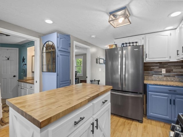 34 Lake Shore Dr S, Westford, MA 01886 - kitchen featuring freestanding refrigerator, wood counters, light wood-type flooring, decorative backsplash, and blue cabinetry