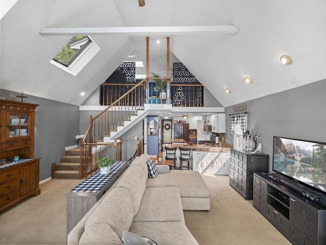 34 Lake Shore Dr S, Westford, MA 01886 - living room with light colored carpet, stairway, high vaulted ceiling, a skylight, and a ceiling fan