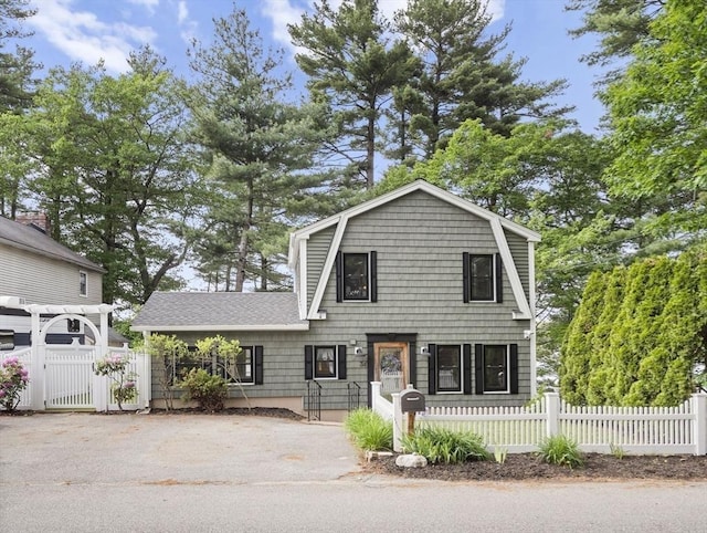 34 Lake Shore Dr S, Westford, MA 01886 - colonial inspired home featuring a gate, a fenced front yard, a gambrel roof, roof with shingles, and driveway