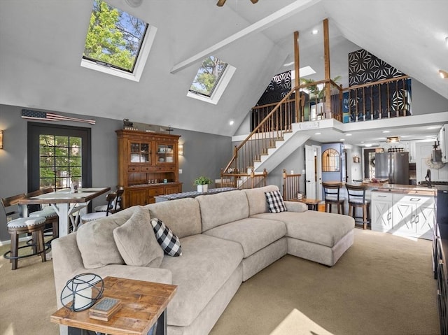 34 Lake Shore Dr S, Westford, MA 01886 - living area featuring high vaulted ceiling, light carpet, a skylight, stairs, and a ceiling fan