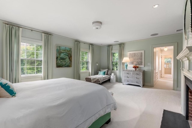 bedroom featuring ensuite bathroom and light carpet