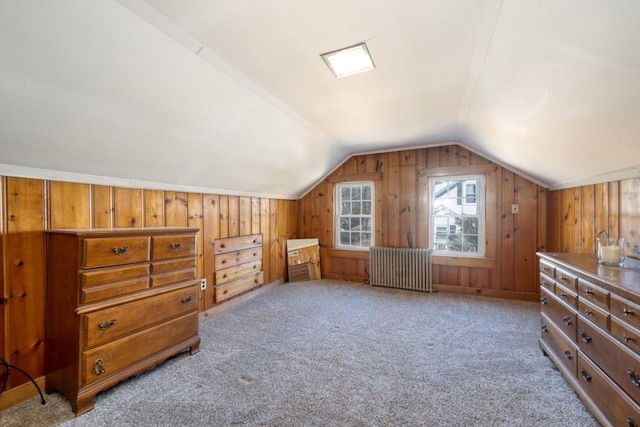 additional living space with lofted ceiling, wooden walls, carpet flooring, and radiator