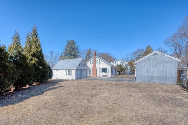 view of front of property featuring a garage and an outbuilding