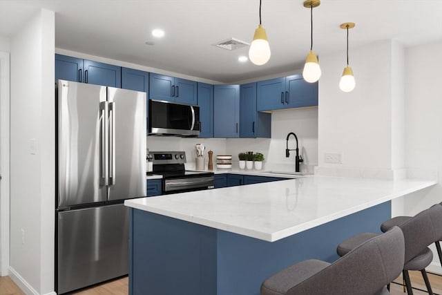 64 Willard St Unit 408, Quincy, MA 02169 - kitchen featuring stainless steel appliances, blue cabinets, a peninsula, a kitchen breakfast bar, and light wood-style flooring