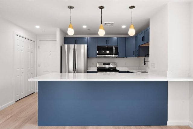 64 Willard St Unit 408, Quincy, MA 02169 - kitchen with appliances with stainless steel finishes, blue cabinets, a peninsula, light countertops, and light wood-type flooring