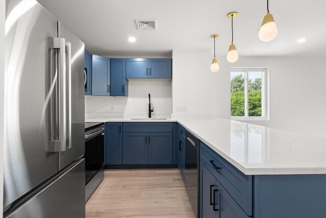 64 Willard St Unit 408, Quincy, MA 02169 - kitchen with appliances with stainless steel finishes, blue cabinetry, a peninsula, light wood-style floors, and recessed lighting