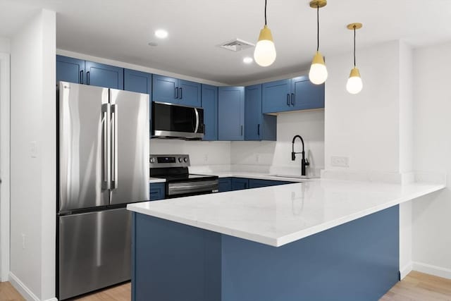 64 Willard St Unit 408, Quincy, MA 02169 - kitchen with appliances with stainless steel finishes, blue cabinetry, a peninsula, light wood finished floors, and a breakfast bar