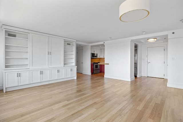 unfurnished living room with light wood-type flooring and baseboards