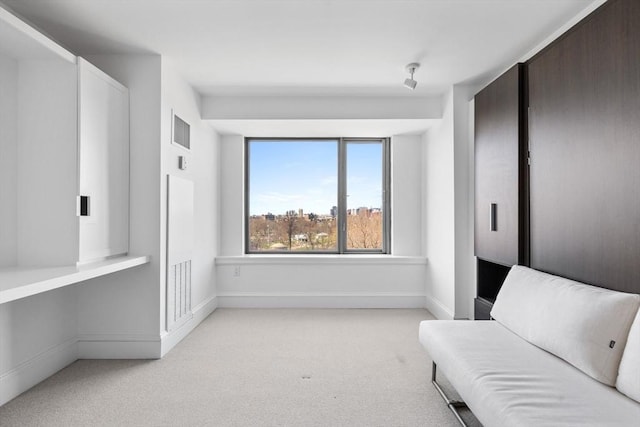 living area featuring light colored carpet and baseboards
