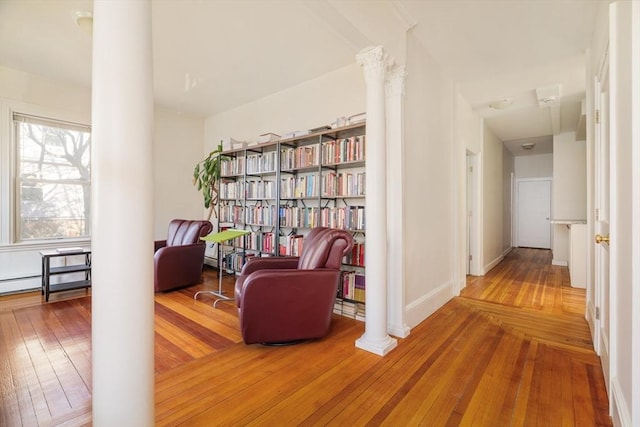 hall with baseboards, decorative columns, and hardwood / wood-style floors