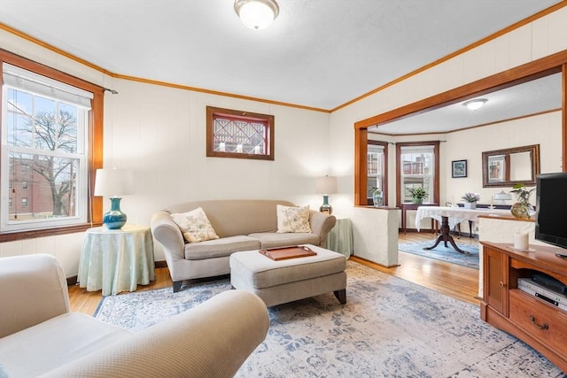 living area featuring a wealth of natural light, wood finished floors, and ornamental molding