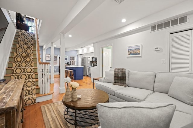 living area with recessed lighting, visible vents, stairway, and light wood-type flooring
