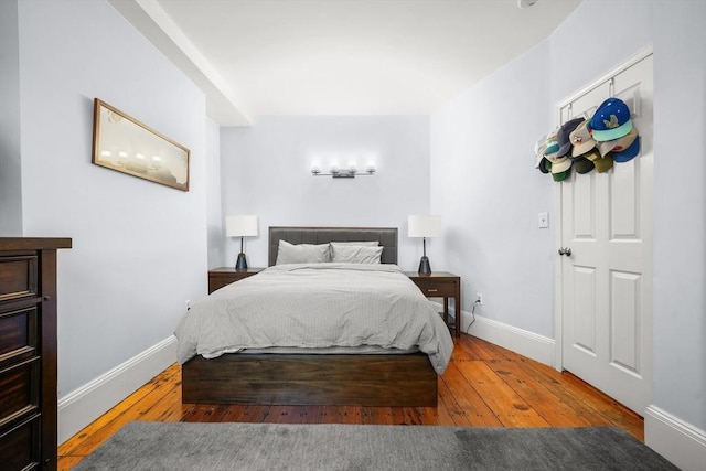 bedroom with baseboards and hardwood / wood-style flooring