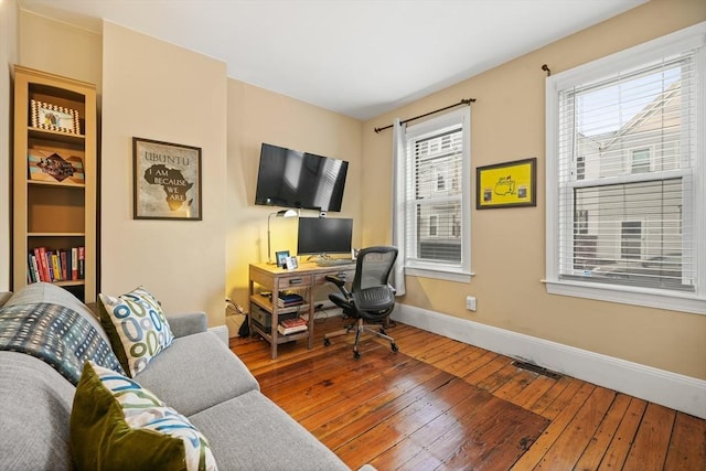 office space featuring baseboards, visible vents, and hardwood / wood-style floors