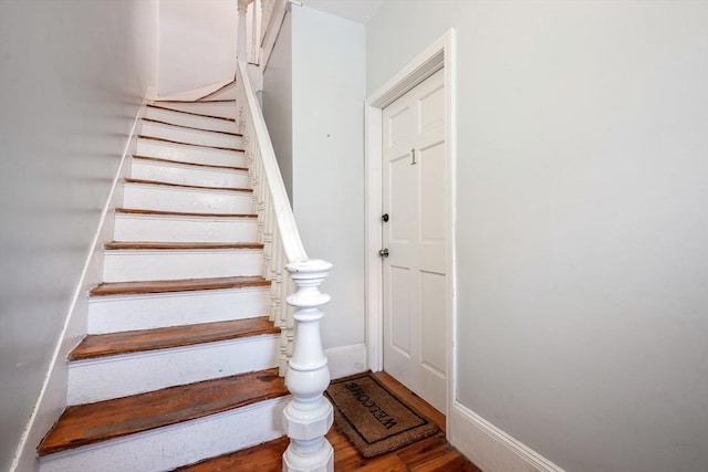 staircase with baseboards and wood finished floors