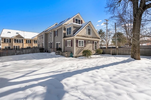 view of snow covered back of property