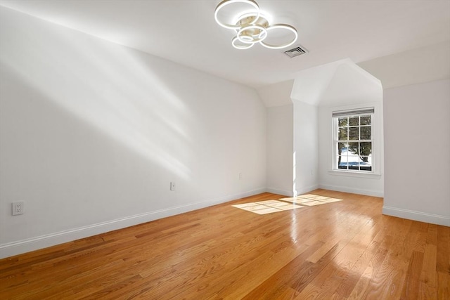 empty room featuring light hardwood / wood-style floors and lofted ceiling