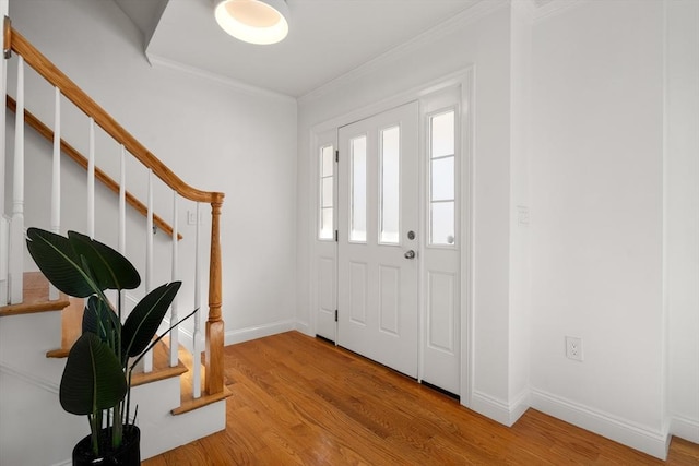 entryway with light hardwood / wood-style flooring and crown molding