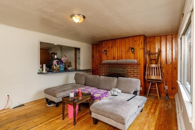 192 Sherbert Rd, Ashburnham, MA 01430 - living area featuring wood walls, a fireplace, visible vents, a baseboard radiator, and hardwood / wood-style flooring