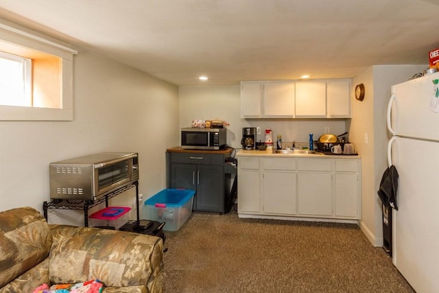 192 Sherbert Rd, Ashburnham, MA 01430 - kitchen featuring a sink, stainless steel microwave, white cabinetry, carpet flooring, and freestanding refrigerator